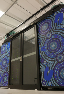 Tall panels decorated with blue Aboriginal artwork separated by sliding glass doors, seen from below.
