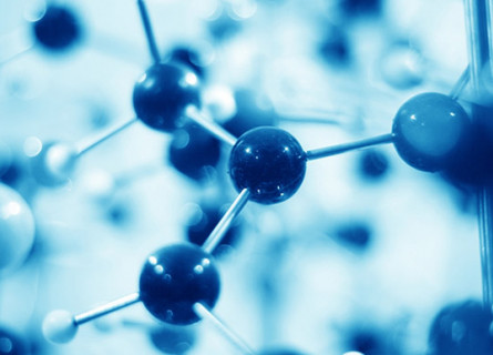 A blue tinted image of a ball and stick model of a molecule with many balls blurry in the foreground and background.