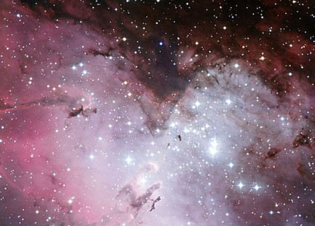 A pink and purple cloud of gas with a huge amount of bright and dim stars dotted around and through it.
