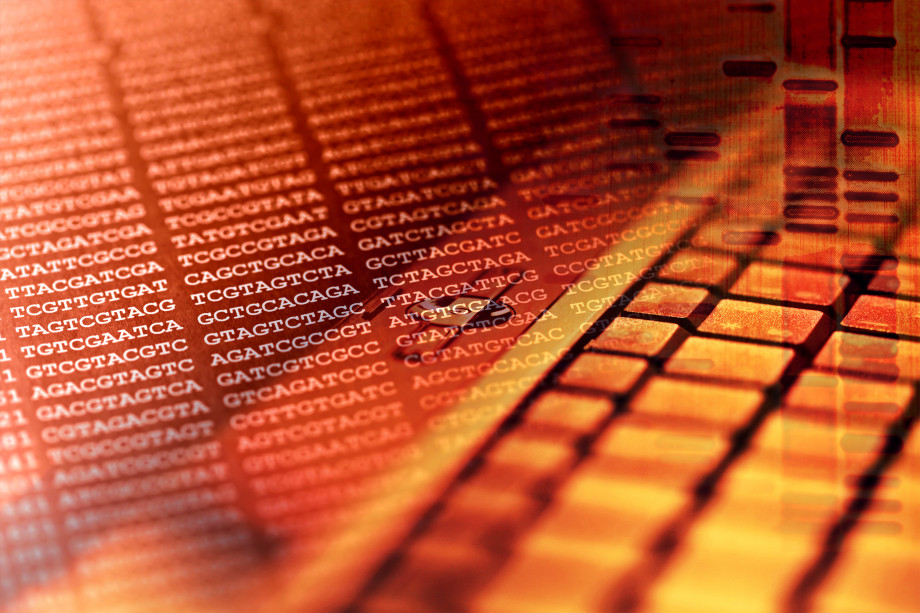 An orange-hued image superimposing letters of a genome with a computer keyboard.