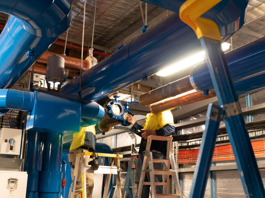 Workers attending to piping in the ceiling.