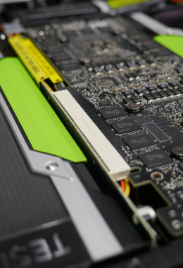Close-up view of tiny transistors and chips alongside the green edges of GPU systems.