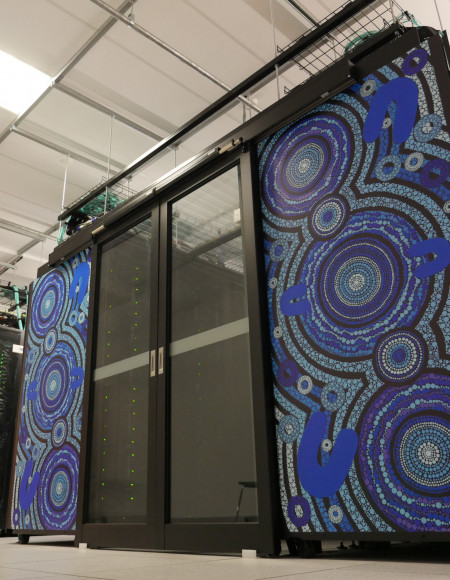 Tall panels decorated with blue Aboriginal artwork separated by sliding glass doors, seen from below.