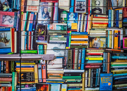 Thousands of colourful books stacked vertically and horizontally.