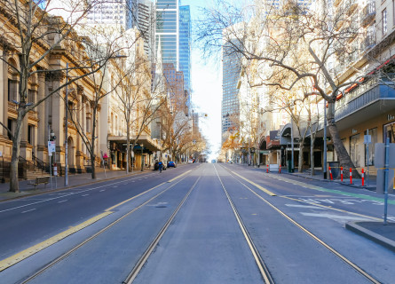 Looking down the middle of an empty street in Melbourne, with no cars and no trams on the tracks.