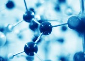 A blue tinted image of a ball and stick model of a molecule with many balls blurry in the foreground and background.