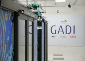 Close-up of the ends of Gadi's supercomputer pods with its distinctive blue artwork visible. The words Gadi are prominently displayed on the wall behind them.