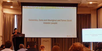 Woman presenting on genomics in front of an audience.